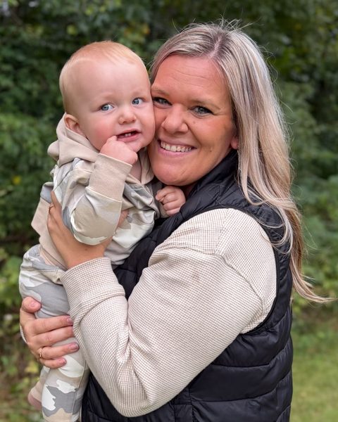 Ashley Gerard holding a baby outdoors